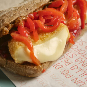 Ciabatta ai semi, brie panato, peperoni arrosto, pesto di noci, chutney di fragole